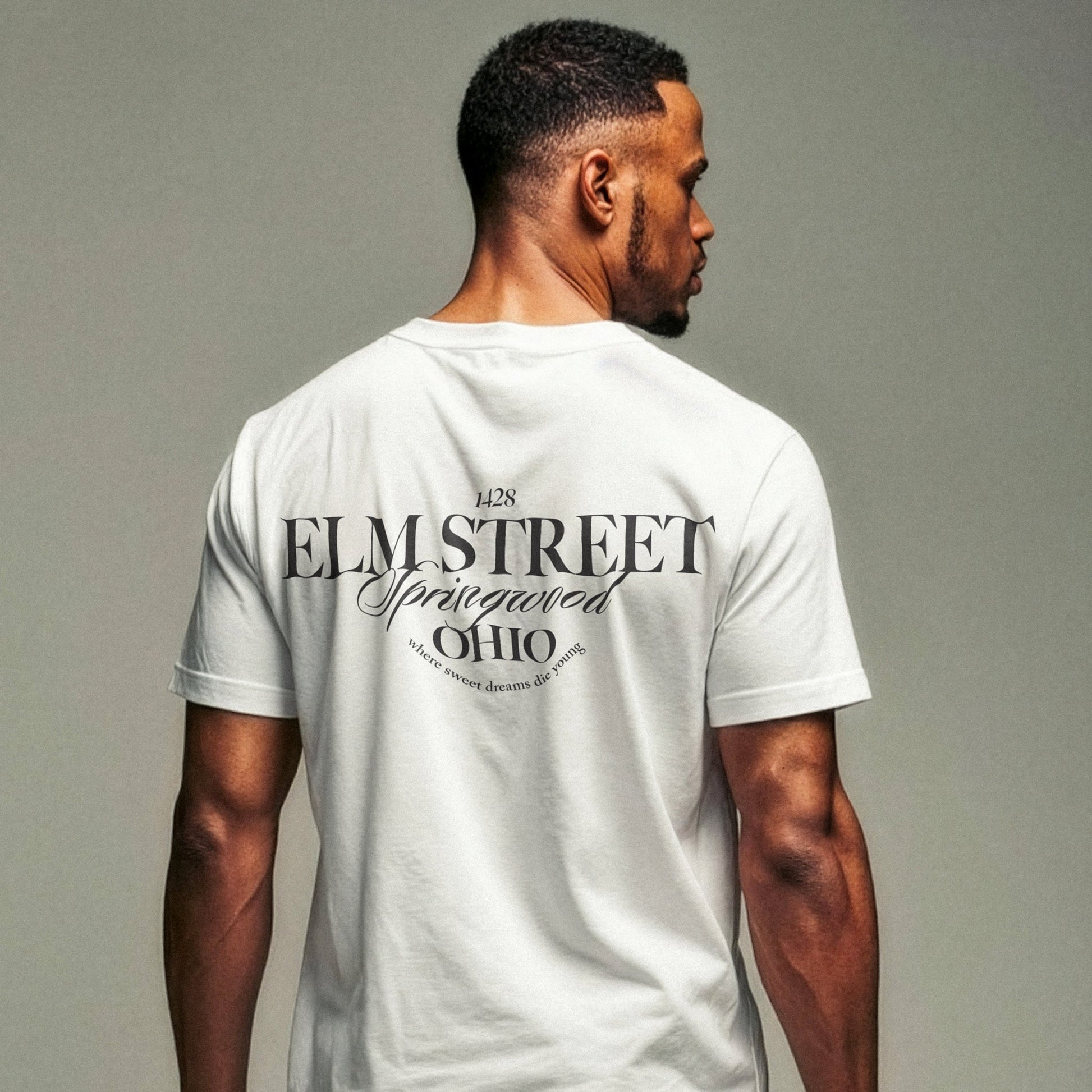 Nahaufnahme männliches Model von hinten in weißem T-Shirt mit Typo-Print "Elmstreet Ohio"