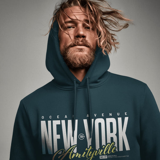 Organic Hoodie 'AMITYVILLE NY' – Mann von vorne, dunkelgrüner Hoodie mit großflächigem Frontprint 'New York Amityville'. Cinematische Nahaufnahme, dramatisches Licht. Premium Cinematic Streetwear. Film Art Wear – Designed in Hamburg.