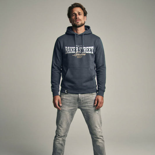 Organic Hoodie 'BAKER STREET' – Mann von vorne, navy Hoodie mit Frontprint 'Baker Street London'. Premium Cinematic Streetwear. Film Art Wear – Designed in Hamburg.