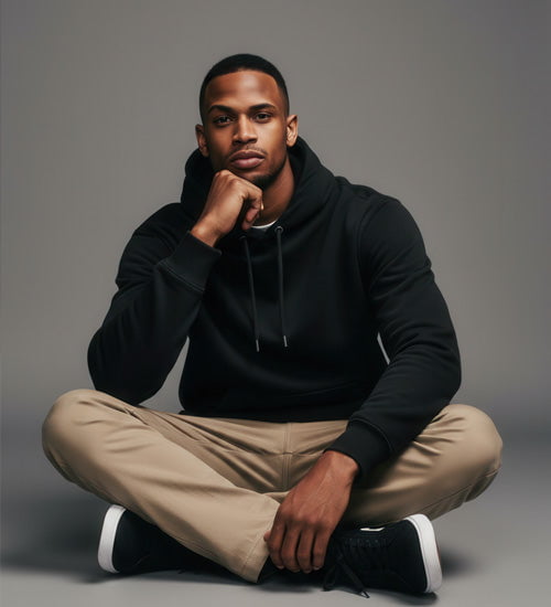 Model mit schwarzem Hoodie im Schneidersitz