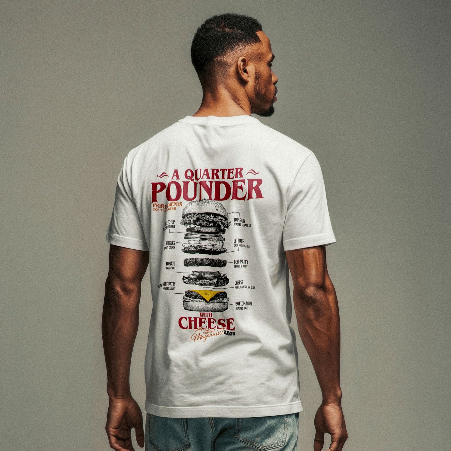 Nahaufnahme eines männliches Models mit Jeans und weißem T-Shirt mit großem Backprint "Quarterpounder with cheese" und der grafischen Zutatenliste