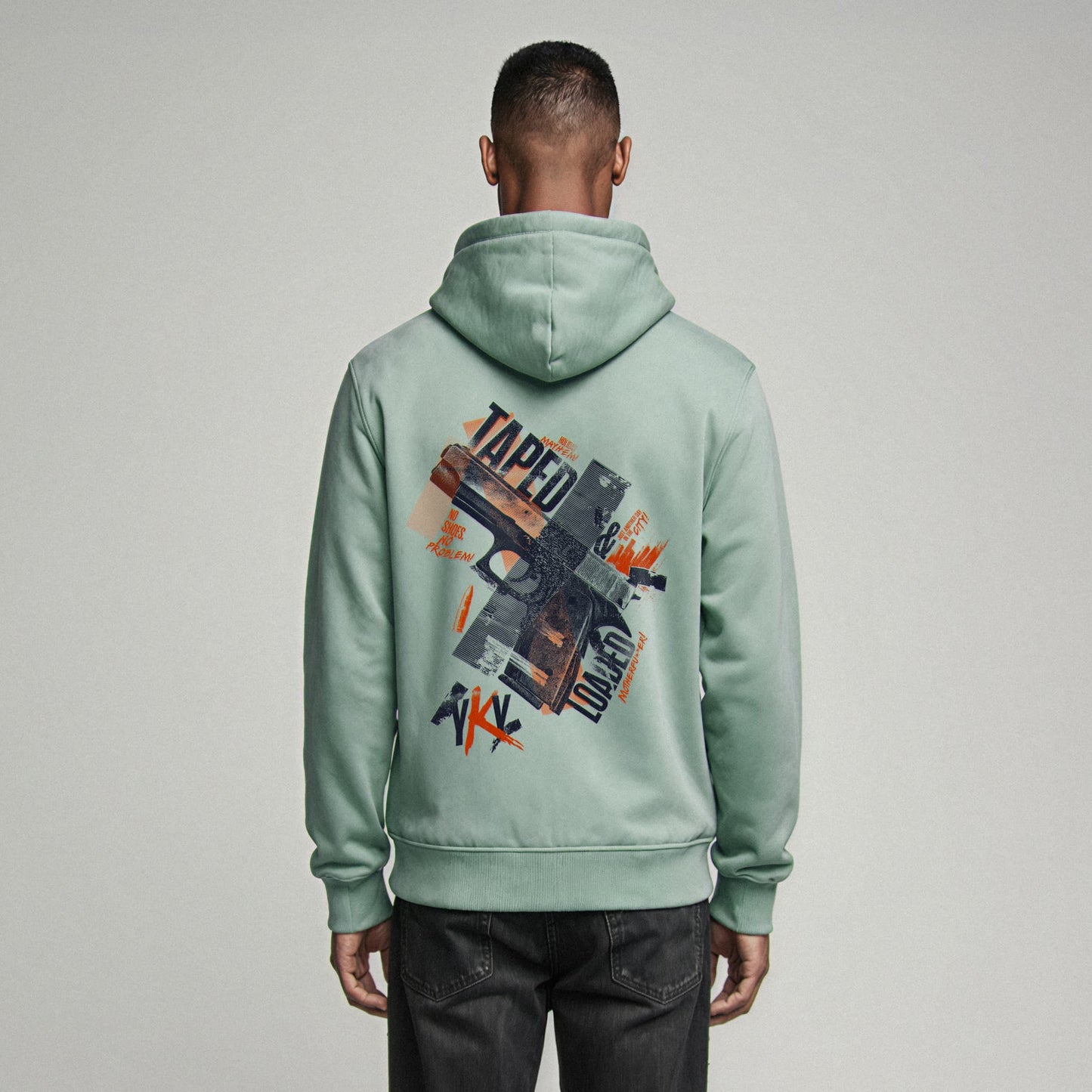 Organic Hoodie 'TAPED & LOADED' – Mann von hinten, mintgrüner Oversize Hoodie mit cinematischem Backprint 'Taped & Loaded'. Heavy Oversize Fit. Premium Cinematic Streetwear. Film Art Wear – Designed in Hamburg.