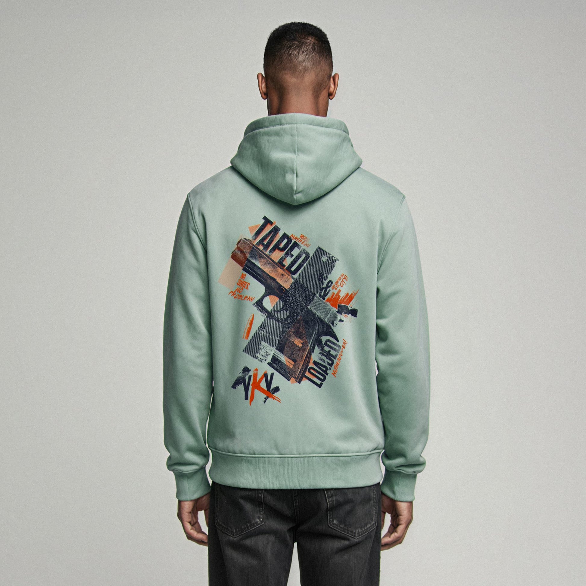 Organic Hoodie 'TAPED & LOADED' – Mann von hinten, mintgrüner Oversize Hoodie mit cinematischem Backprint 'Taped & Loaded'. Heavy Oversize Fit. Premium Cinematic Streetwear. Film Art Wear – Designed in Hamburg.
